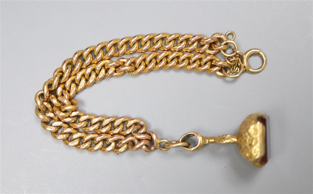 An early 20th century 9ct gold curblink bracelet, hung with a yellow metal overlaid carnelian set fob seal,